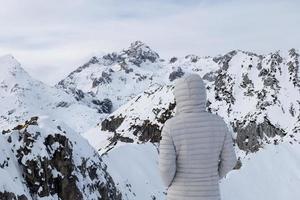 une personne admirant le vaste paysage de montagne d'hiver avec le mont triglav en arrière-plan dans les alpes juliennes en slovénie. randonnée en hiver. neige dans les montagnes. sentiment de voyage et d'esprit libre. photo
