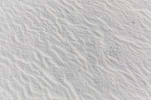 gros plan sur la texture du sable de la plage en été. motif de plage naturelle de sable blanc photo