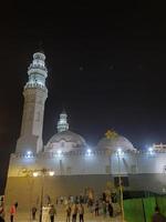 médina, arabie saoudite, décembre 2022 - une belle vue sur les minarets et le dôme de la mosquée quba à médina, arabie saoudite la nuit. photo