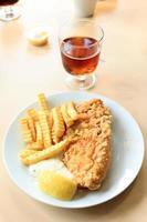 fish and chips avec sauce tartare, frites et citron. photo