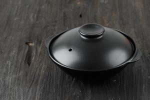 nabe noir avec couvercle sur table en bois photo