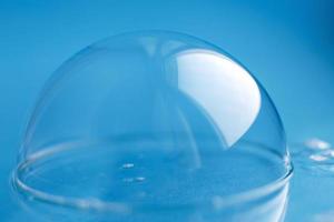 bulle de savon en gros plan. fond abstrait eau bleue photo