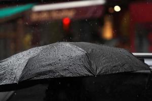 Parapluie noir ouvert sous de fortes pluies dans le quartier chinois de New York photo