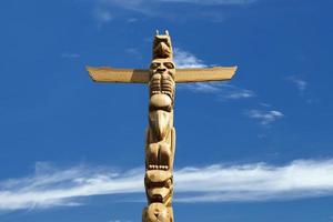 un poteau en bois de totem dans le fond bleu nuageux photo