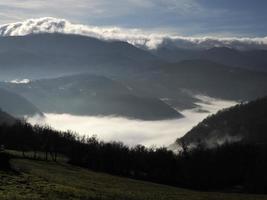 Des nuages bas comme du brouillard dans la vallée des Apennins autour d'une formation rocheuse en pierre de Bismantova dans les Apennins toscans et émiliens photo