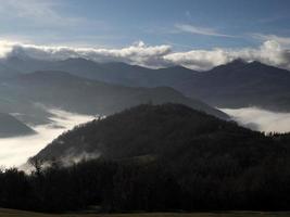 Des nuages bas comme du brouillard dans la vallée des Apennins autour d'une formation rocheuse en pierre de Bismantova dans les Apennins toscans et émiliens photo