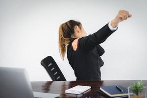 femme d'affaires souffrant de douleurs à l'épaule sur le lieu de travail. photo