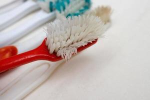 Un tas de vieilles brosses à dents usées avec des poils courbés sur un fond blanc photo