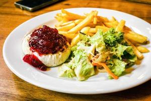 fromage hermelin grillé avec salade de légumes et frites sur assiette photo