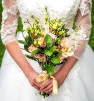 mariée tenant un beau gros bouquet de mariage photo