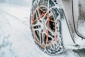 Chaînes à neige sur le pneu à la route d'hiver photo