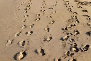 empreintes de pas dans le sable au bord de la mer photo