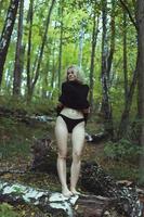 modèle blonde enlevant des vêtements dans la photographie scénique en bois photo