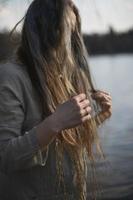 gros plan femme en vêtements de lin touchant des mèches de cheveux bruns gris photo portrait