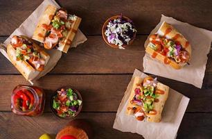hot-dog - sandwich à la salsa mexicaine sur fond de bois. vue de dessus photo