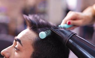 coiffeur professionnel coupe les cheveux des hommes dans un salon de beauté. photo