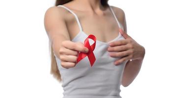 femme tenant un ruban rouge pour la journée mondiale du sida de décembre. concept de soins de santé photo
