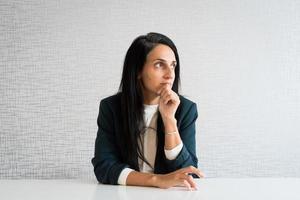 jeune femme d'affaires caucasienne au bureau concept réfléchi. une femme travaillant en regardant par la fenêtre dans une maquette de bureau au travail a un dilemme isolé photo