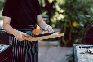 serveuse servant des croissants dans le café en plein air. photo