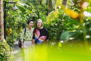 mère senior et fille souriante debout dans le jardin en vacances. photo