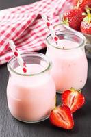 milk-shake aux fraises dans le bocal en verre sur fond d'ardoise noire photo