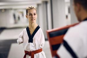 combattante de taekwondo sans bras ayant un entraînement sportif avec son partenaire d'entraînement dans un club de santé. photo