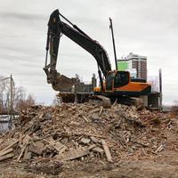 démolition d'un vieux bâtiment par une excavatrice moderne photo