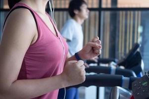 les athlètes s'entraînent dans la salle de fitness. les personnes en bonne santé courent sur un tapis roulant dans la salle de fitness pour faire de l'exercice. photo