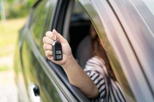 un employé d'une société de location de voitures de tourisme présente les clés de la voiture avec un essai routier. bon service avant de conclure un contrat de location ou d'achat. photo