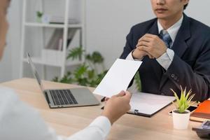 les hommes d'affaires envoient des lettres de démission aux cadres ou aux gestionnaires. inclure des informations sur les démissions, les postes vacants et les changements d'emploi. photo