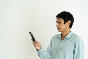 l'homme asiatique est choqué en regardant un téléphone portable. les hommes font des expressions faciales, des messages surprises ou des choses qui apparaissent sur leurs téléphones. photo