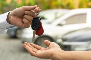 vente de voiture, vente de voiture, concept de transaction le concessionnaire donne les clés de la voiture au nouveau propriétaire ou locataire avec un contrat d'assurance. photo