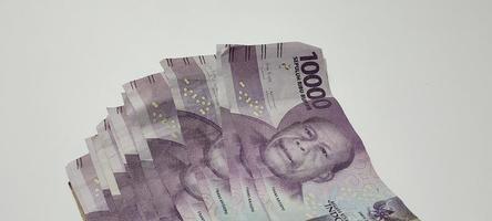 plusieurs feuilles de billets de 10 000 roupies indonésiennes isolés sur fond blanc. fond de concept d'argent photo