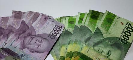 plusieurs feuilles de billets indonésiens nominaux 10000 et 20000 isolés sur fond blanc. illustration conceptuelle d'affaires d'argent photo