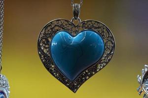 Pendentif coeur turquoise isolé sur jaune photo