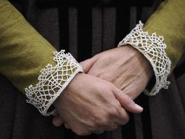 détail des mains croisées d'une femme portant une robe médiévale photo