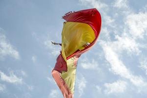 agitant le drapeau espagnol dans le ciel bleu photo