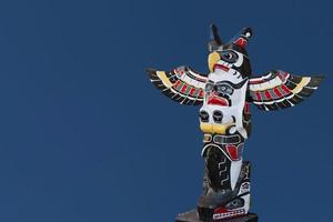 un poteau en bois de totem dans le fond bleu photo