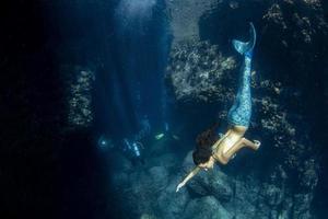 sirène nageant sous l'eau dans la mer d'un bleu profond photo