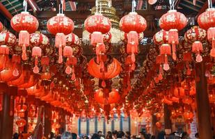 lanternes rouges chinoises dans le temple, joyeuses fêtes du nouvel an lunaire. phrase chinoise signifie bonheur, en bonne santé, chanceux et riche photo