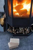 briquettes de combustible en sciure de bois pressée pour allumer le four - combustible écologique alternatif économique pour la cheminée de la maison. le bois de chauffage brûle dans le four à l'intérieur photo