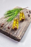 produits de spa et concept d'aromathérapie conifère avec de petites bouteilles en verre d'huile essentielle de cèdre sur une vieille planche de bois. photo
