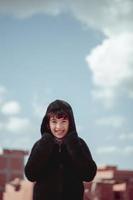 portrait d'une belle petite fille portant une veste de fourrure sous un ciel bleu photo