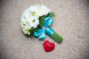 Anneaux de mariage en or dans une boîte rouge et bouquet de mariée photo