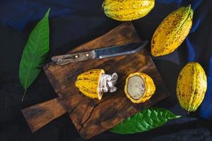 couper les fruits de cacao sur une planche à découper en bois. photo