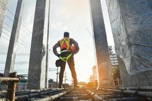 travailleur portant un harnais de sécurité et une ligne de sécurité travaillant en hauteur travail sur chantier concepts de bâtiment résidentiel en construction photo