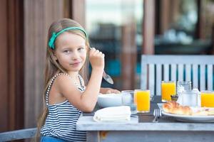 fille prenant son petit déjeuner dans un café en plein air photo