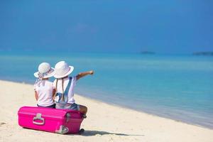 deux filles assis sur des bagages sur une plage photo