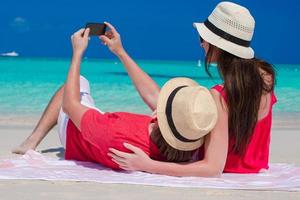 couple prenant une photo d'eux-mêmes sur une plage