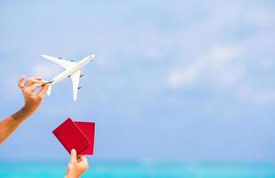 mains tenant des passeports et un avion jouet photo